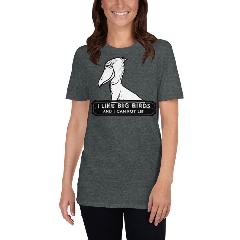 May include: Dark gray t-shirt featuring a Shoebill bird illustration. The shirt has the text "I LIKE BIG BIRDS AND I CANNOT LIE" in a black and white design. The shirt is made of a soft material.