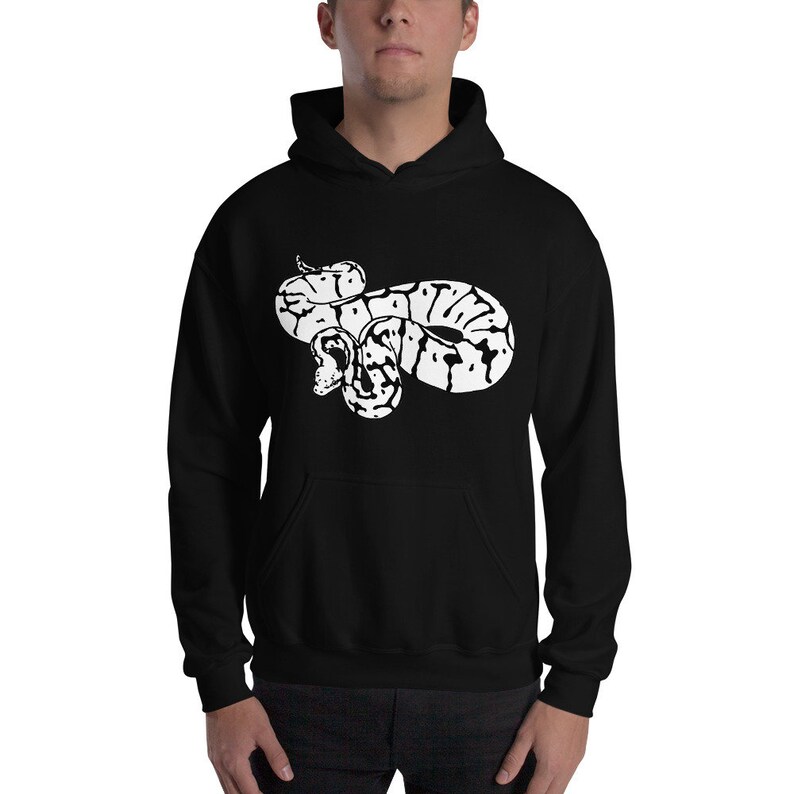 May include: Black hooded sweatshirt featuring a white graphic of a coiled snake. The snake design has a detailed pattern with black and white markings. The sweatshirt has a front pocket and a drawstring hood.