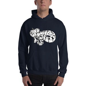 May include: Navy blue hoodie featuring a white graphic of a coiled snake. The snake design has black and white markings. The hoodie has a front pocket and a hood with drawstrings. The model is wearing the hoodie.