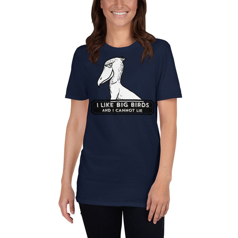 May include: Navy blue t-shirt featuring a Shoebill bird illustration. The shirt has the text "I LIKE BIG BIRDS AND I CANNOT LIE" in a black and white design. The shirt is a short-sleeved crew neck.