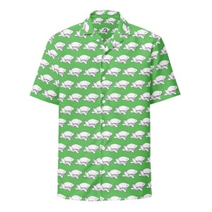 Puede incluir: Camisa verde de manga corta con un estampado repetido de ilustraciones de tortugas blancas. La camisa tiene un cuello clásico y cierre de botones. El diseño de tortuga proporciona un aspecto divertido e informal.