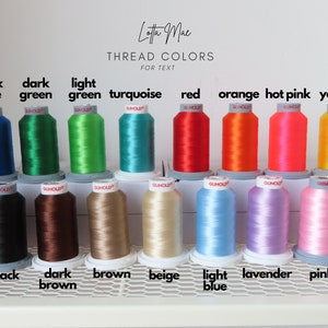 May include: A collection of spools of embroidery thread in various colors, including dark blue, dark green, light green, turquoise, red, orange, hot pink, yellow, purple, black, dark brown, brown, beige, light blue, lavender, pink, and white. The spools are arranged in two rows on a white shelf with a metal grid.