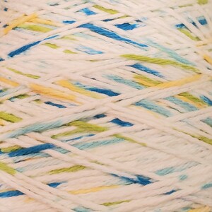 May include: A skein of white yarn with blue, yellow, and green stripes. The yarn is wound into a ball shape.