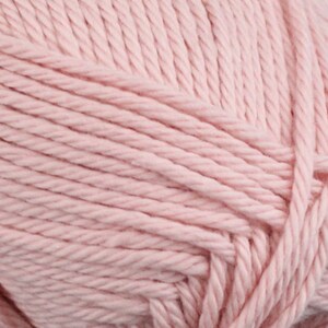Op de afbeelding: Close-up van een zacht, roze garen. Het garen is gemaakt van katoen en is perfect om te breien of haken.