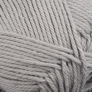 May include: A close-up of a skein of light gray yarn. The yarn is made of cotton and is soft and fluffy.