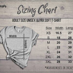 May include: A gray unisex ultra-soft t-shirt with a sizing chart. The chart lists sizes XS to 3XL, with corresponding width and length measurements in inches. The shirt is displayed on a wooden background.