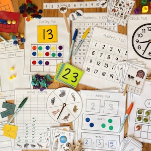 May include: A collection of educational materials for teaching math, including counting mats, number charts, adding mats, a clock, and animal graphing activities. The materials are printed on white paper with black ink and feature colorful illustrations.