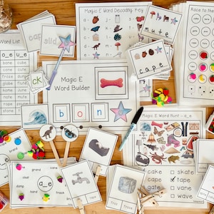 Puede incluir: Un conjunto de materiales educativos para enseñar a los niños la regla de fonética "Magic E". El conjunto incluye una lista de palabras, un constructor de palabras, una clave de decodificación, una búsqueda de palabras y un tablero de juego. Los materiales presentan ilustraciones coloridas y están diseñados para ser atractivos para los jóvenes estudiantes.