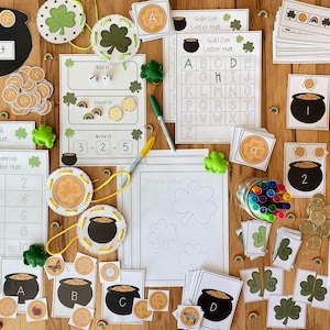 May include: A collection of St. Patrick's Day themed educational activities for kids. The activities include counting coins, letter matching, number recognition, and writing practice. There are also shamrock-shaped cutouts and a pot of gold.