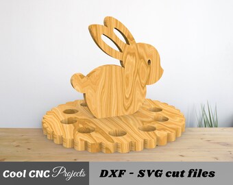 Könnte beinhalten: Ausgeschnittener Holzhase mit einem runden Sockel, der 10 Löcher zum Halten von Eiern hat. Der Hase steht auf dem Sockel.  DXF - SVG Schnittdateien.