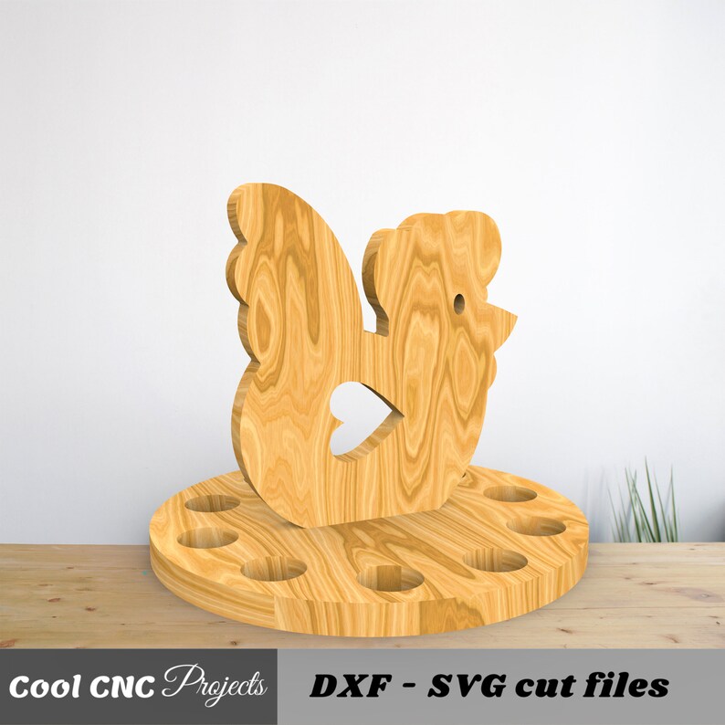 K&ouml;nnte beinhalten: Eierhalter aus Holz in Form eines Huhns mit sechs L&ouml;chern f&uuml;r Eier. Das Huhn steht auf einem runden Sockel. Sockel und Huhn sind aus Naturholz.