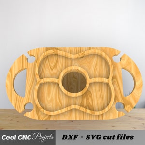 May include: A wooden serving tray with a cutout design for holding snacks and drinks. The tray has two bottle holders on the sides and a large center section with three smaller compartments.  DXF - SVG cut files.
