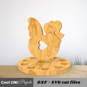 K&ouml;nnte beinhalten: H&uuml;hner-Eierhalter aus Holz mit 10 L&ouml;chern zum Aufbewahren von Eiern. Das Huhn steht auf einem runden Sockel.