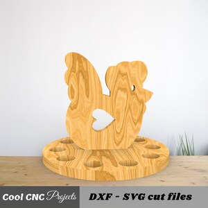 K&ouml;nnte beinhalten: H&uuml;hner-Eierhalter aus Holz mit 12 L&ouml;chern zum Aufbewahren von Eiern. Das Huhn ist mit einem Herz auf dem Fl&uuml;gel geschnitzt.  DXF - SVG Schnittdateien.