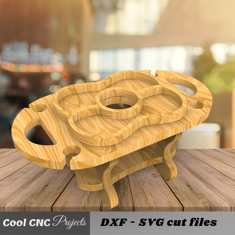 May include: Wooden serving tray with a guitar shape and multiple compartments. The tray has two handles and a lower shelf. The tray is made of light brown wood and is sitting on a wooden surface.