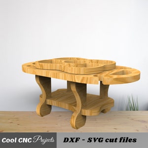 May include: Wooden serving table with a top shelf and a lower shelf. The top shelf has a cutout design for holding bottles and glasses. The table is made of light brown wood.