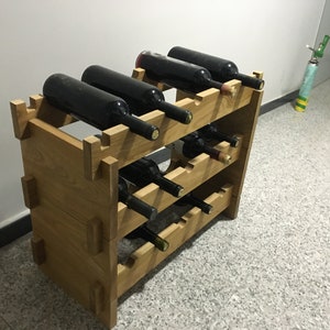 May include: A wooden wine rack with multiple shelves, holding several bottles of wine. The rack is made of natural wood and has a rustic look.