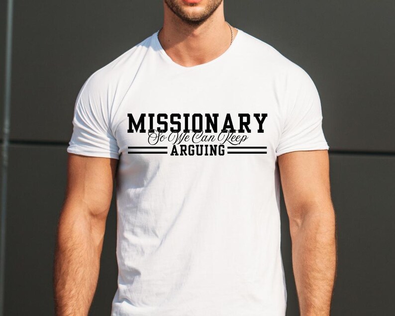 Puede incluir: Camiseta blanca con el texto negro "MISSIONARY So We Can Keep Arguing". El texto est&aacute; centrado, con l&iacute;neas que separan las palabras. La camiseta tiene mangas cortas y cuello redondo. La tela es suave.