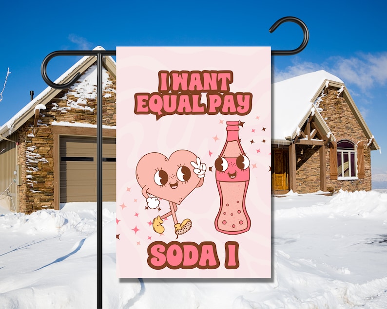 May include: A pink garden flag with a cartoon heart and soda bottle. The text on the flag reads "I want equal pay soda I".