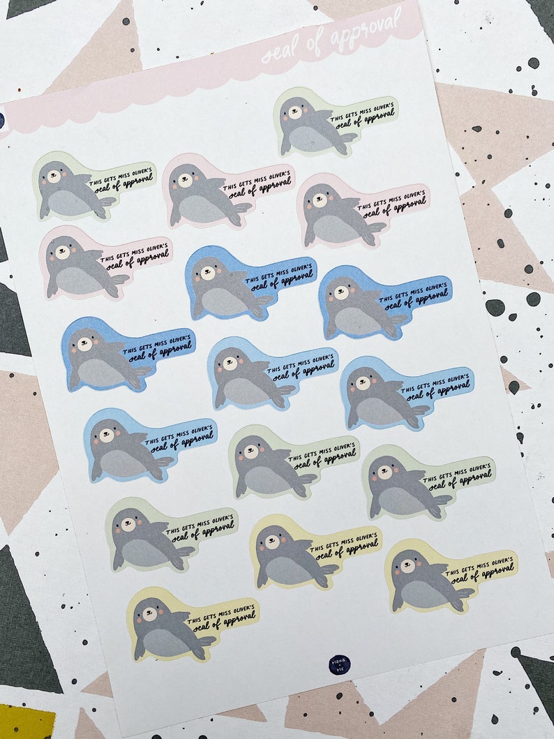 May include: A sheet of stickers featuring cartoon seals with the text "This gets Miss Oliver's seal of approval" repeated on each sticker. The stickers are in various pastel colors.