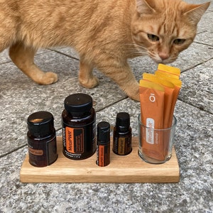 Könnte beinhalten: Ein Holzorganizer mit vier Glasflaschen und einem Glasgefäß gefüllt mit orangefarbenen Packungen. Die Flaschen sind mit "MetaPWR" beschriftet und die Packungen mit "MetaPWR Advantage".
