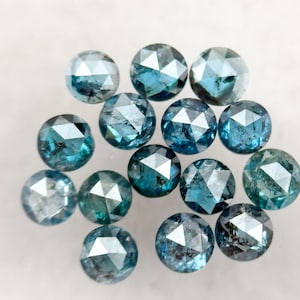 Peut inclure: Une collection de pierres précieuses rondes et facettées dans différentes nuances de bleu et de turquoise. Les pierres précieuses sont dispersées sur une surface blanche, mettant en valeur leurs coupes complexes et leurs surfaces réfléchissantes. Les gemmes mesurent environ 0,6 cm de diamètre.