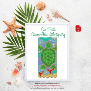 May include: A framed tapestry with a sea turtle design, resembling stained glass. The artwork features a green turtle, blue and turquoise geometric shapes, and a sandy beach scene. The text "Sea Turtle Stained Glass little tapestry" is displayed.