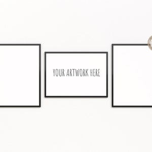 May include: Three black picture frames on a white wall. The middle frame has the text "YOUR ARTWORK HERE" in black.