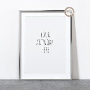 Peut inclure: Un cadre photo argenté avec un passe-partout blanc et un fond blanc. Le texte "YOUR ARTWORK HERE" est imprimé en noir sur le fond blanc.