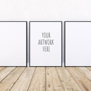 Könnte beinhalten: Drei schwarze Bilderrahmen mit weißen Passepartouts hängen an einer weißen Wand über einem Holzboden. Der mittlere Rahmen trägt den Text "YOUR ARTWORK HERE" in Schwarz.