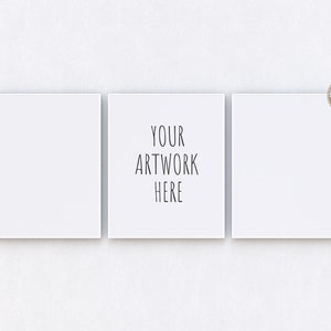 Peut inclure: Trois cadres carrés blancs avec un fond blanc, le cadre du milieu contient le texte "YOUR ARTWORK HERE" en noir.