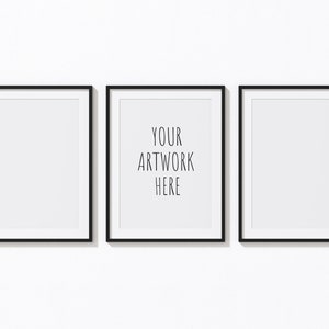 Könnte beinhalten: Drei schwarze Bilderrahmen mit weißen Passepartouts hängen an einer weißen Wand. Der mittlere Rahmen hat den Text "YOUR ARTWORK HERE" im Inneren.