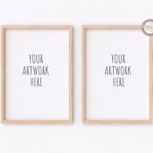 May include: Two wooden picture frames with white mats, each with the text "YOUR ARTWORK HERE" inside. The frames are hanging on a white wall.