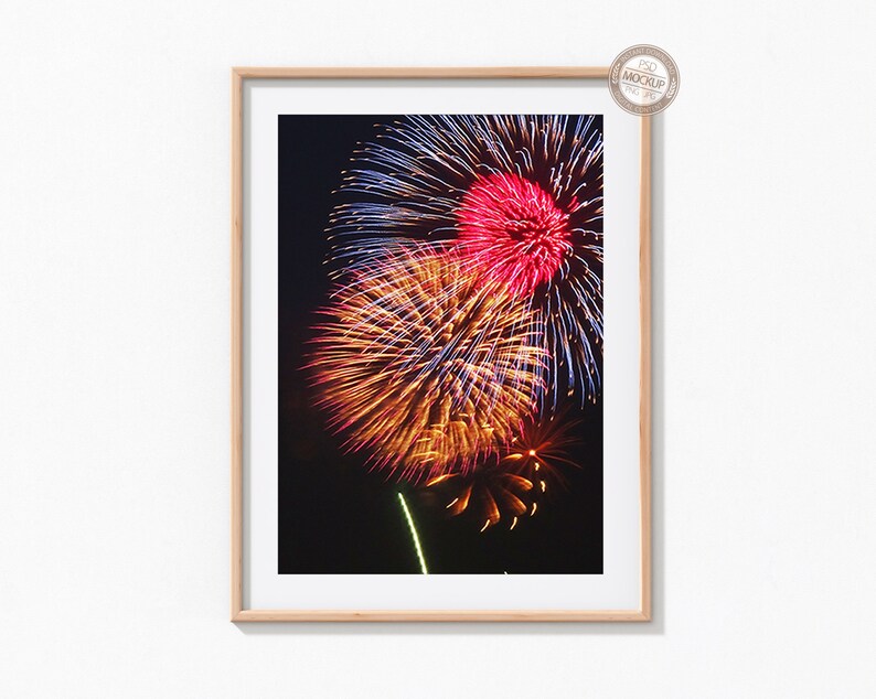 May include: A framed photograph of a colorful fireworks display against a dark night sky. The fireworks are red, orange, yellow, and blue.