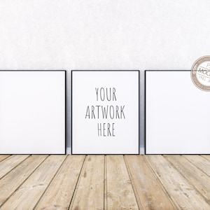 Peut inclure: Trois toiles carrées encadrées de noir sur un sol en bois. La toile du centre porte le texte "YOUR ARTWORK HERE" en noir.
