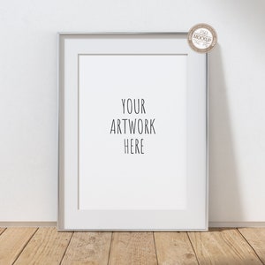 May include: A silver frame mockup with a white mount and a white background. The text "YOUR ARTWORK HERE" is printed in black on the white mount.