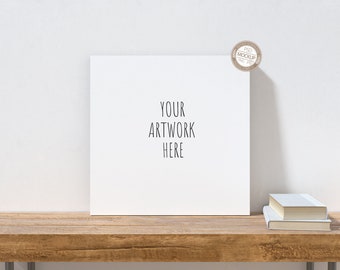 Mockup di tela quadrata, tela su desktop Mock Up, sfondo neutro, accessori per libri, modello di tela, scrivania in legno, immagine stock, PSD+PNG+JPG