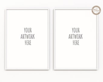 May include: Two white picture frames with thin black frames hanging on a white wall. The text "YOUR ARTWORK HERE" is written in black inside each frame.