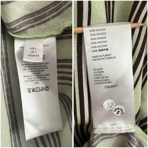 May include: A green and brown striped shirt with a white care label. The label includes the text "100% Viscose", "Made in Turkey", "RN 66170", "CA 32054", "For EU", "URBN UK Ltd.", "146 Brick Lane", "London E1 6RU", and "OB1311619".