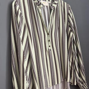 May include: A green and black striped long-sleeved blouse with a ruffled collar and a single button closure. The blouse has a slightly gathered hem.