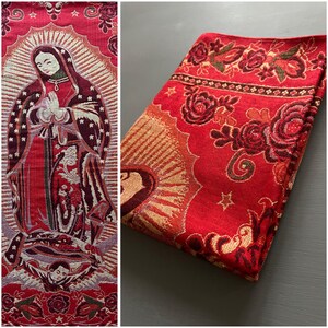 May include: Red and gold tapestry featuring a depiction of the Virgin Mary with a crown of stars. The tapestry has a floral border with red roses and green leaves.