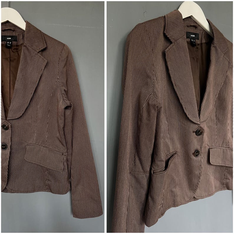 K&ouml;nnte beinhalten: Ein brauner Blazer mit wei&szlig;en Streifen, einem Reverskragen und Zwei-Knopf-Verschluss. Der Blazer hat zwei Eingrifftaschen und einen Schlitz am R&uuml;cken.
