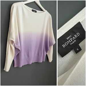 May include: A white and purple ombre sweater with long sleeves. The sweater has a round neckline and a relaxed fit. The label reads "ERIC BOMPARD PARIS" and the size is "S".