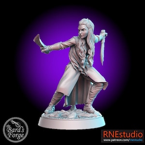 May include: A white painted miniature figurine of a female warrior with long hair, holding a dagger in one hand and a sword in the other. The figurine is posed in a dynamic fighting stance.