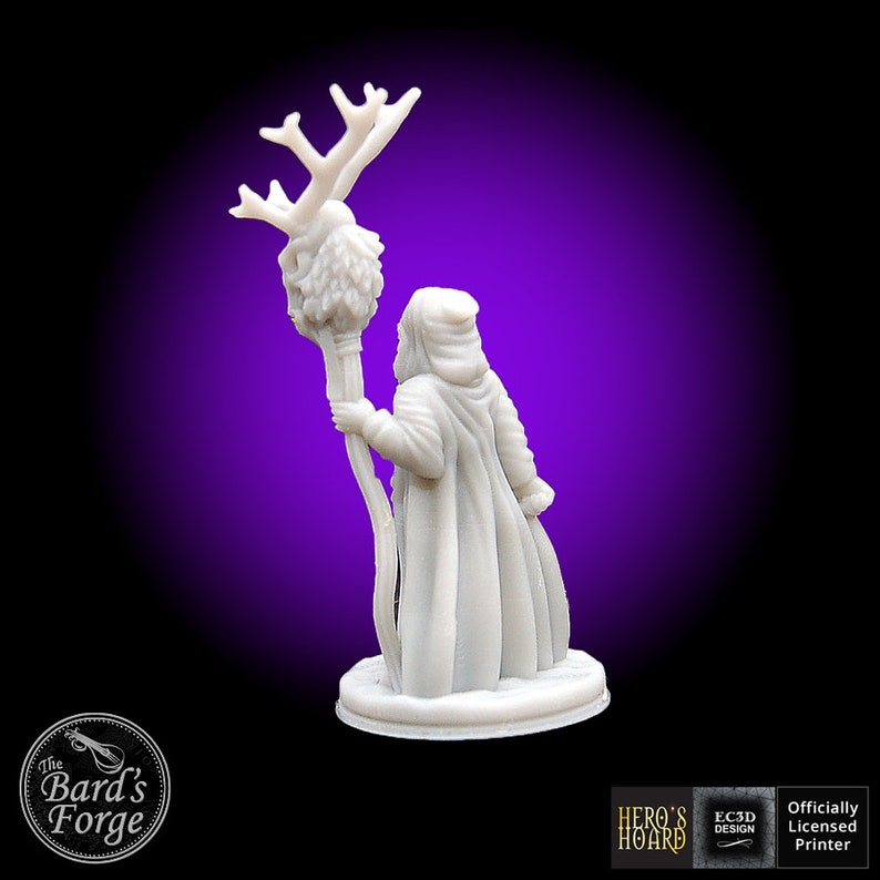 May include: White 3D printed miniature of a wizard holding a staff with a deer skull and antlers at the top. The wizard is wearing a hooded robe and is standing on a round base.