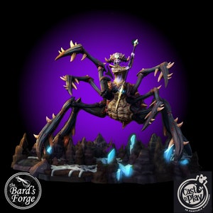 May include: A 3D printed miniature of a spider-like creature with a female humanoid figure riding on its back. The creature has a dark brown exoskeleton with sharp spines and eight legs. The figure is wearing a golden armor with a crown and holding a staff. The miniature is set on a rocky base with blue crystals.