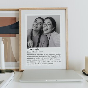 May include: Black and white photo of two women smiling and laughing. The photo is framed and has a definition of the word "Trauzeugin" in German, which means "maid of honor" in English. The definition explains that a maid of honor is someone who is very close to the bride and is there to support her on her wedding day.