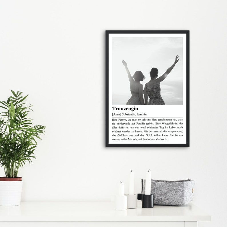 May include: Black and white photo of two people with their arms raised in the air. The photo is in a black frame with a white background. The text below the photo reads "Trauzeugin [Anna] Substantiv, feminin Eine Person, die man so sehr ins Herz geschlossen hat, dass sie mittlerweile zur Familie geh&ouml;rt. Eine Weggef&auml;hrtin, die alles daf&uuml;r tut, um den wohl sch&ouml;nsten Tag im Leben noch sch&ouml;ner werden zu lassen. Mit der man all die Anspannung, das Gef&uuml;hlschaos und das Gl&uuml;ck teilen kann. Sie ist ein wundervoller Mensch, auf den immer Verlass ist."