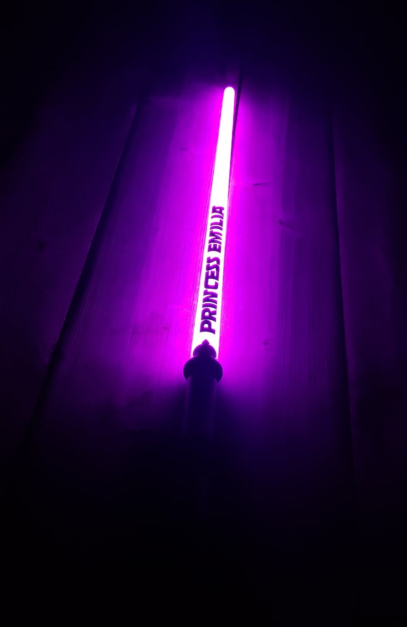 Peut inclure: Un b&acirc;ton lumineux violet avec le texte "Princess Emilia" imprim&eacute; dessus.