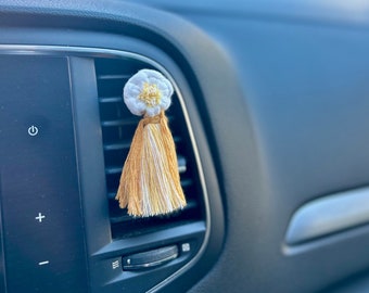 Ansteckbarer Autodiffusor zur Vernebelung ätherischer Öle, aus Makramee mit gänseblümchenförmigem Zopf.